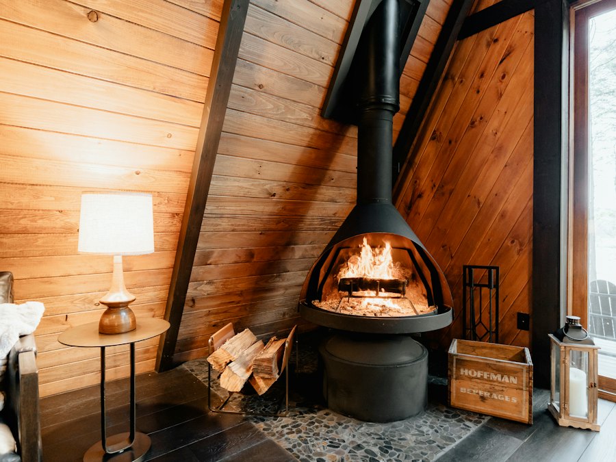 A wood stove burning in a timber cabin